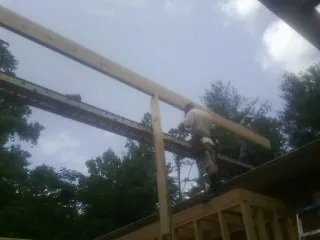 Carpenter setting a ridge beam over a new addition frame — Ice Dam Removal by Roofing Brothers in Quakertown