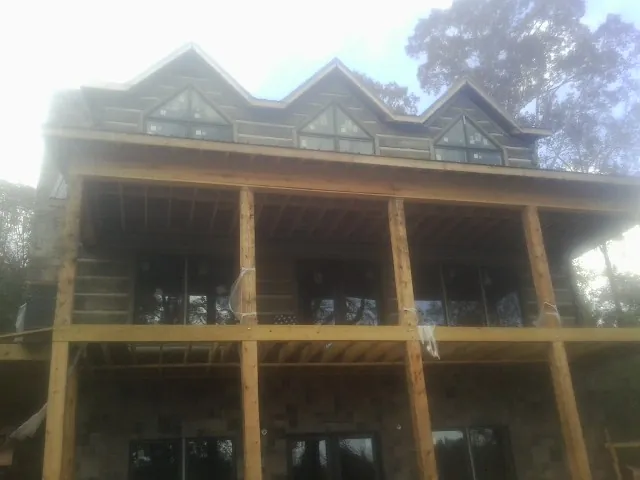 Dormers and porch framing on a large log home under construction — Roof Coating work by our crew in Quakertown