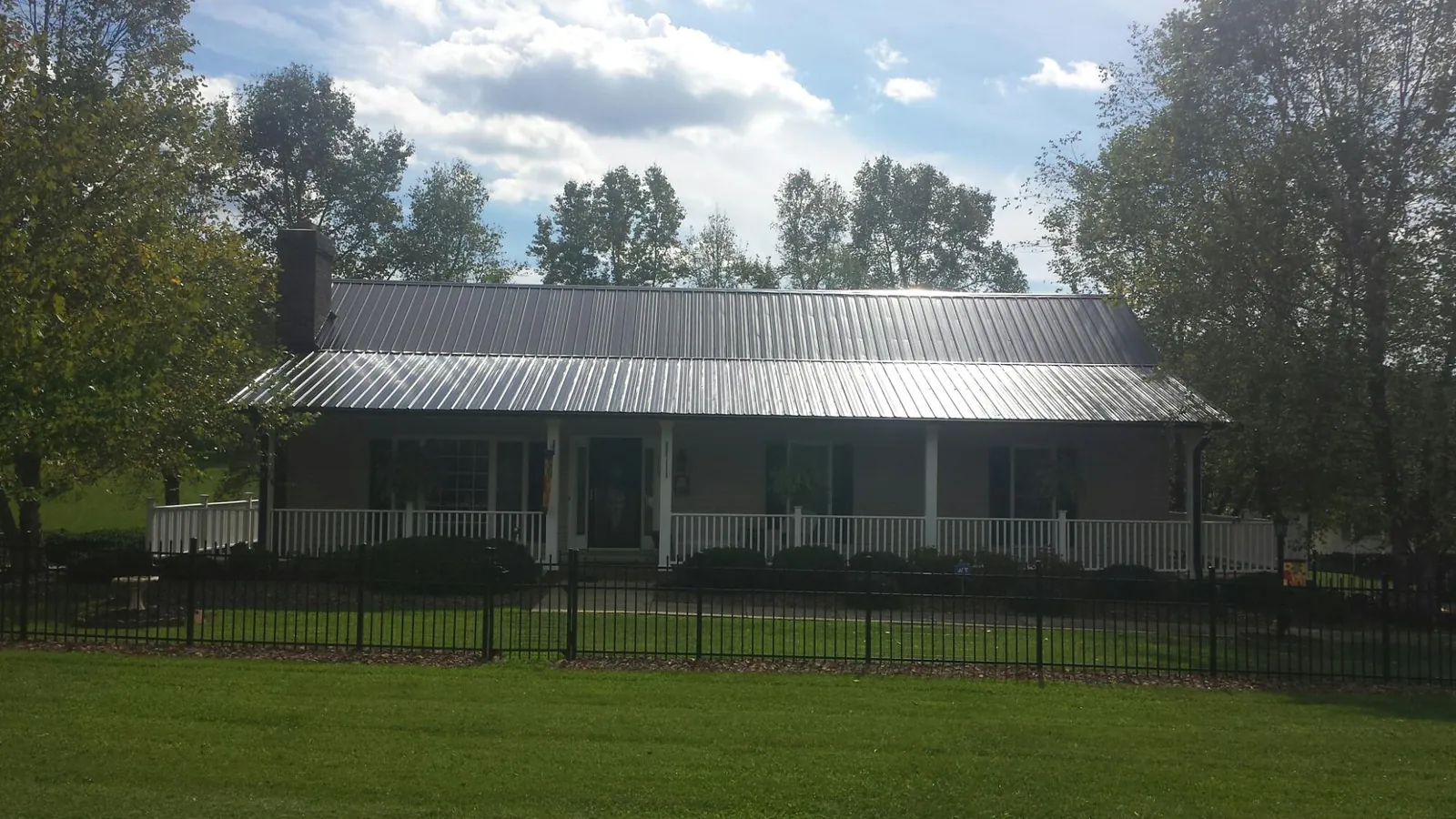 Gray metal roof on a brick ranch with a full width front porch — Gutter Guard Installation work by our crew in Quakertown