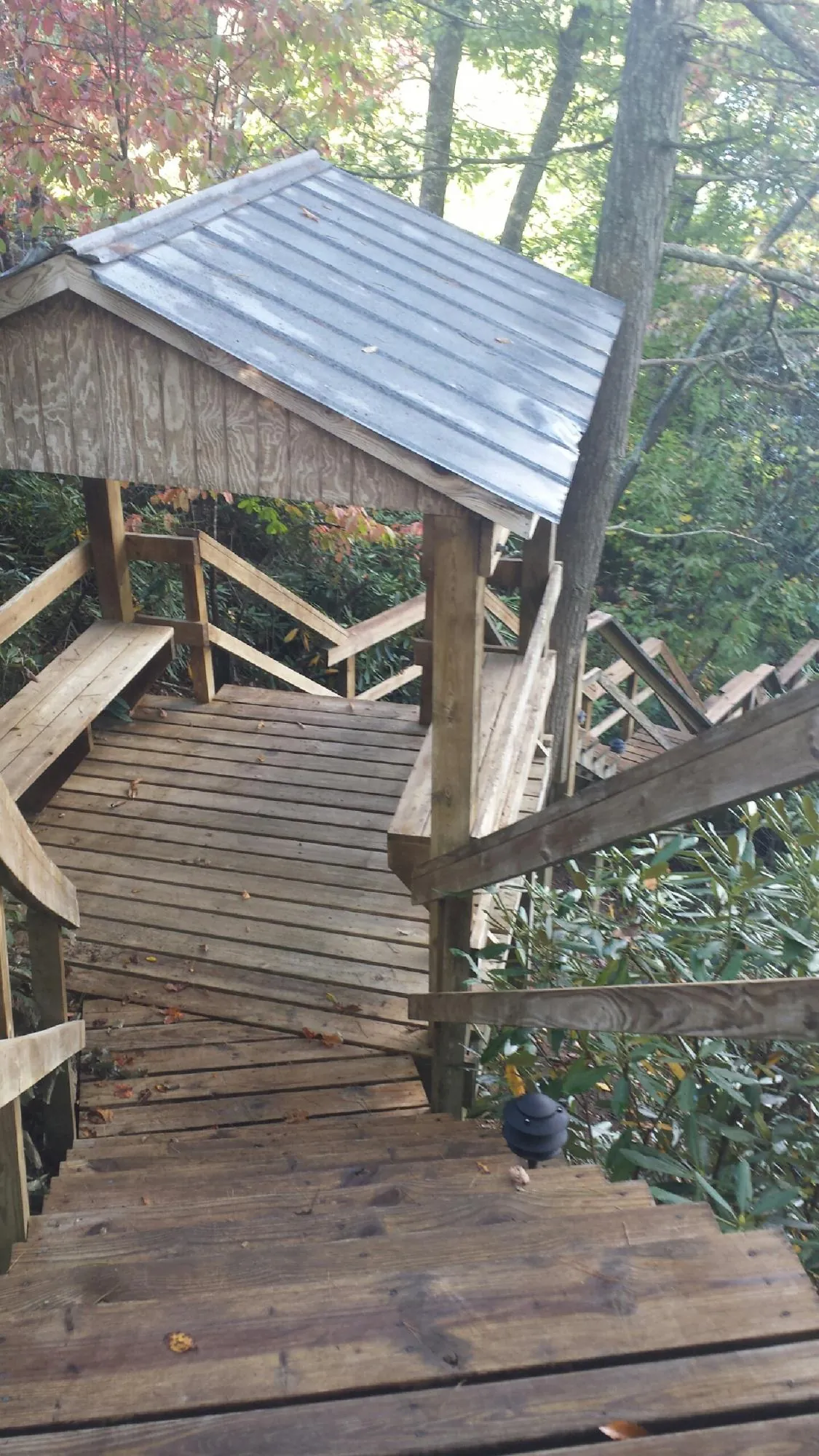 Metal roofed shelter over wooden steps on a wooded walkway — Skylight Repair & Installation work by our crew in Quakertown