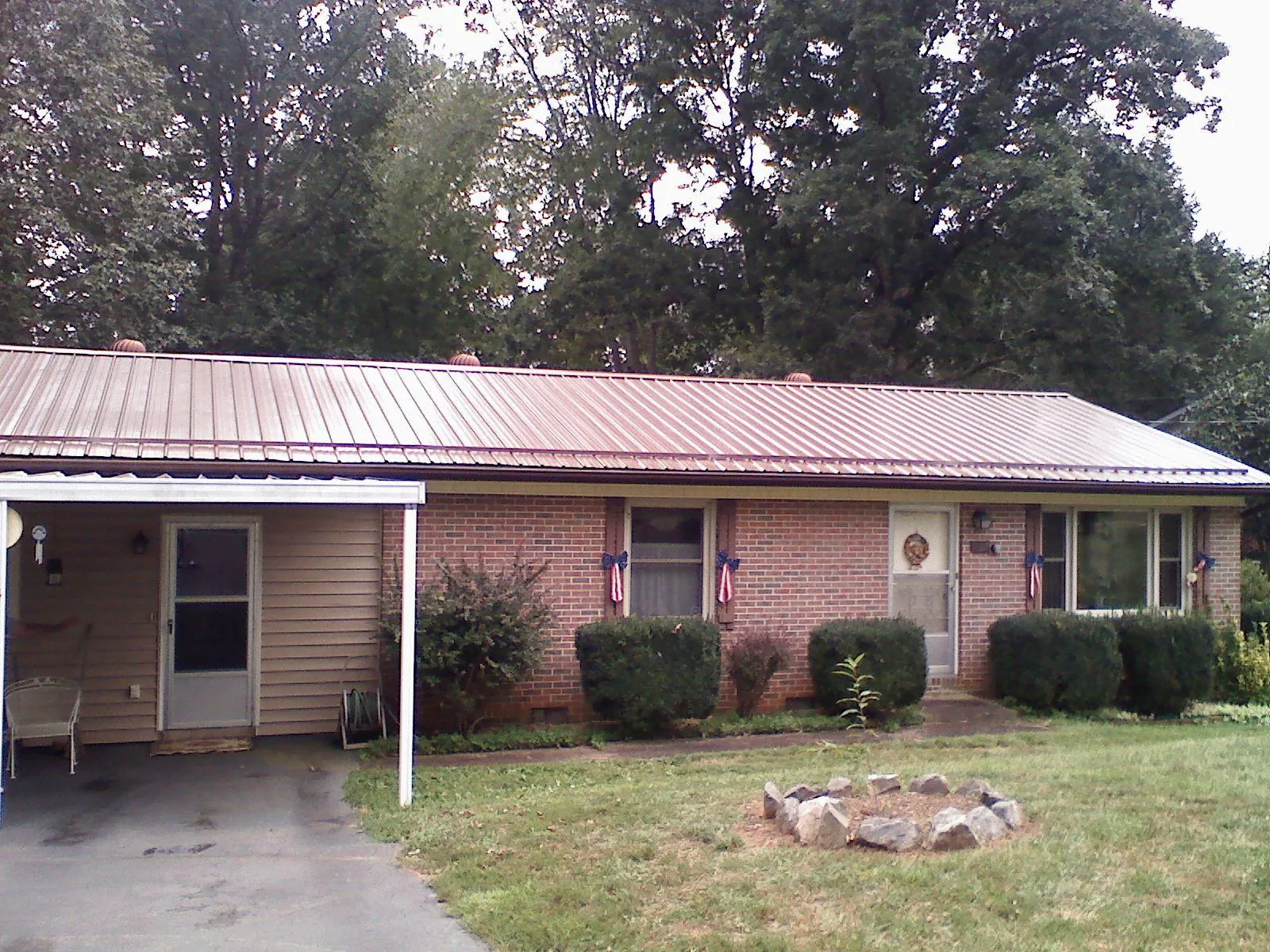 Bronze metal roof and carport on a brick ranch home — Roof Repair work by our crew in Quakertown